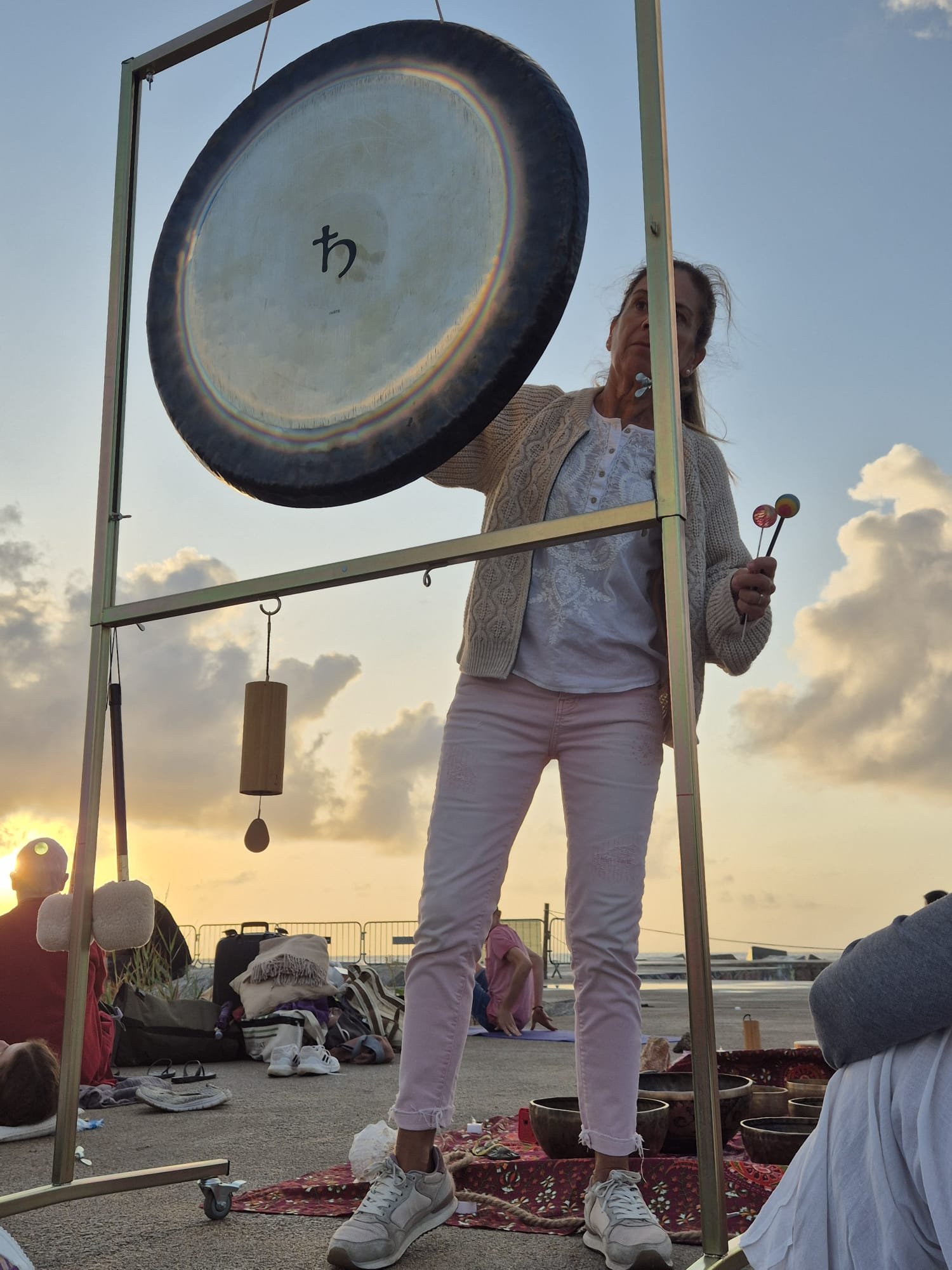 Montse tocando el gong al atardecer