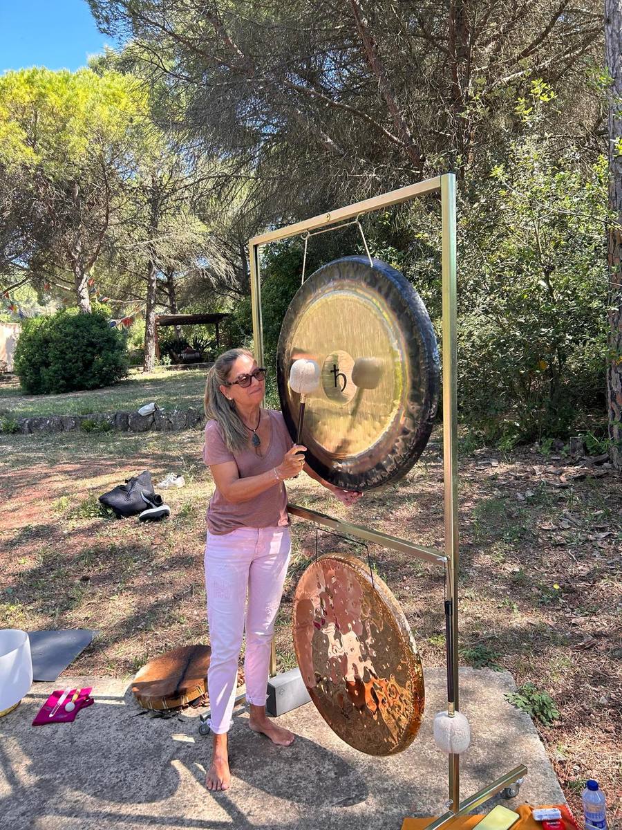 Montse con gong planetario dorado al aire libre