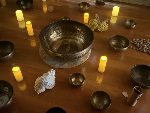 Altar de cuencos tibetanos y cuenco grabado con velas en un baño de sonido