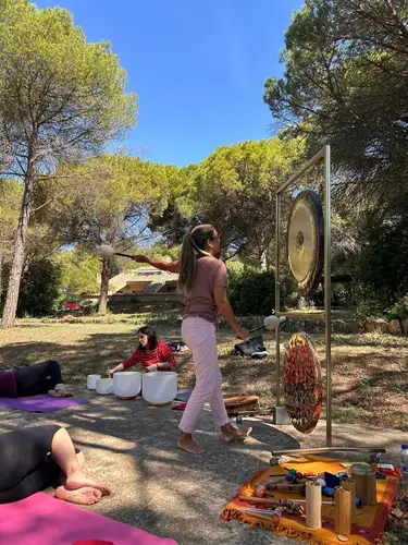 Montse junto al gong y cuencos de cuarzo en sesión en el bosque