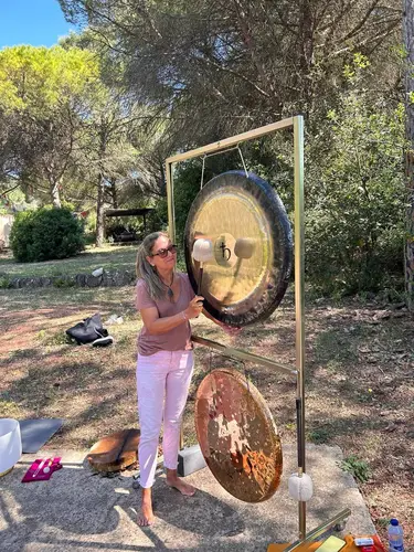 Montse con gong planetario dorado al aire libre