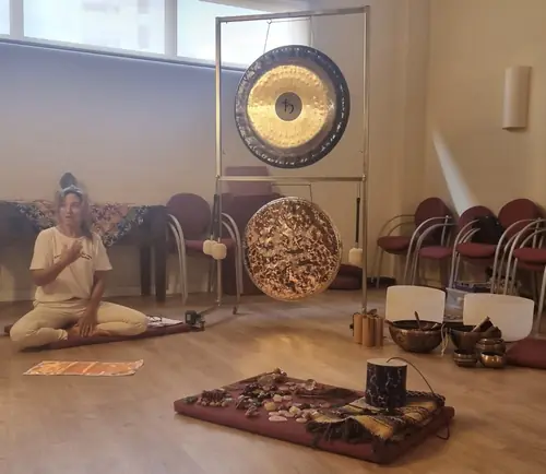Montse sentada en la sala con gong y cuencos