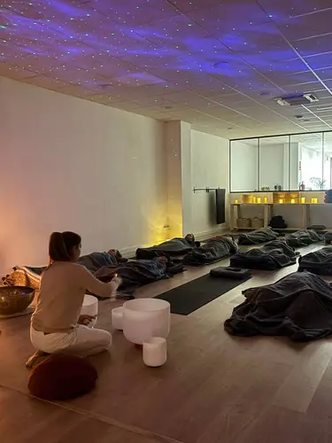 Sesión grupal en sala con cielo estrellado y cuencos de cuarzo