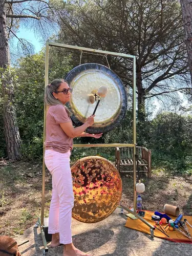 Montse tocando el gong en el bosque