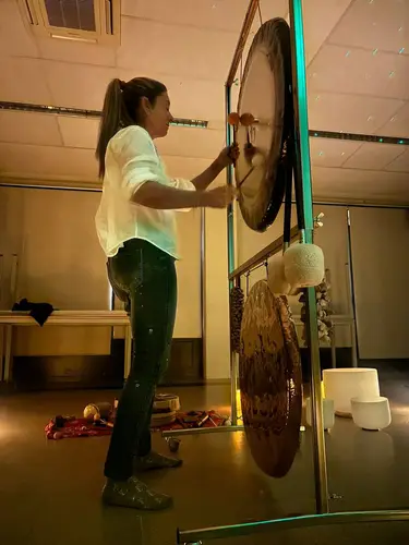 Montse tocando los gongs en una sesión con velas
